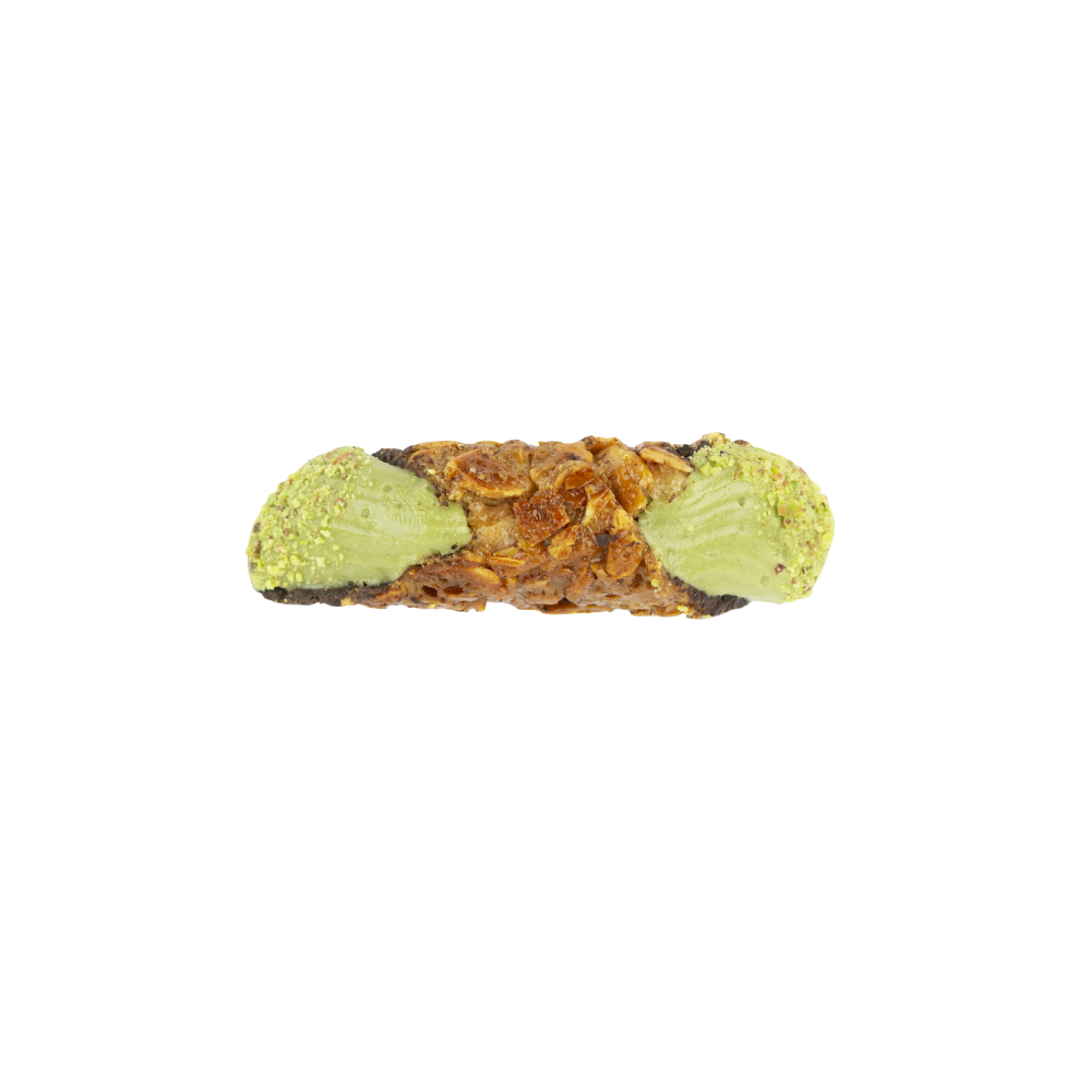 Close up of green pistachio cream filling inside almond brittle cannoli shell